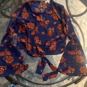 Navy blue blouse with brownish-orange flower detailing with flared sleeves